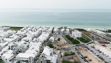 Spin-Motion-Ansicht-Der-Weißen-Häuser-Von-Alys-Beach,-Meerseite-Im-Hintergrund,-Einige-Häuser-Im-Bau-Und-Autos-Auf-Dem-Parkplatz-Auf-Der-Rechten-Seite,