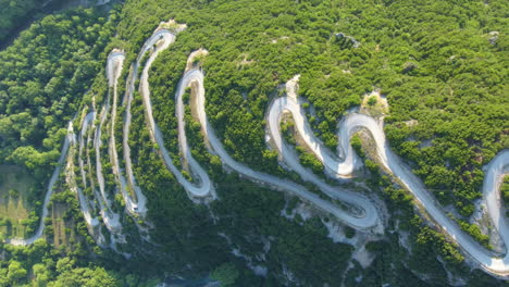 The-winding-road-with-multiple-curves-leads-toward-Papigko-village-in-the-picturesque-mountainous-region-of-Zagori,-located-in-the-Epirus-region-of-Greece,-Europe