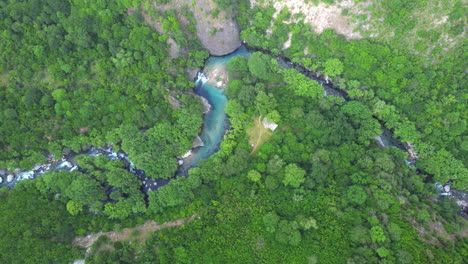 Eine-Luftaufnahme-Des-Flusses,-Der-Durch-Eine-Mit-üppigen-Wäldern-Geschmückte-Landschaft-Fließt