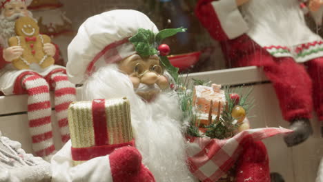 Santa-Claus-And-Various-Other-Christmas-Ornaments-In-A-Shop-Window,-Medium-Close-up