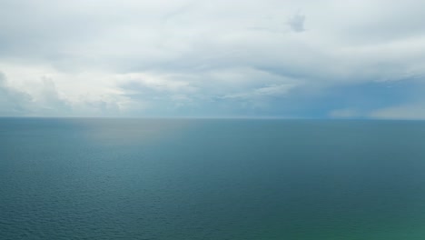 Slow-straight-forward-motion-on-Gulf-of-Mexico-Ocean-from-Rosemary-Beach-with-cloudy-blue-sky-and-sun-light-coming-through
