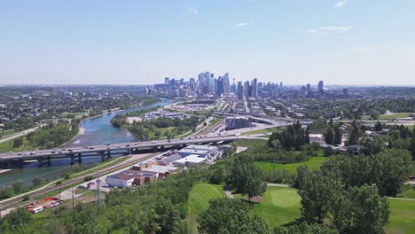 Flying-over-Shaganappi-golf-course-with-the-bow-river-and-the-vista-downtown-of-Calgary-Alberta-Canada-coming-more-into-view