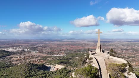 Aerial-approaching-shot-of-famous-stony-cross-Creu-des-Picot-on-Puig-de-Sant-Salvador,-Mallorca