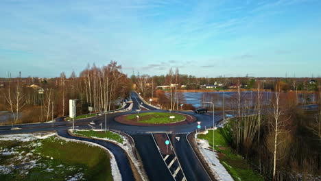 Aerial-Drone-Above-asphalt-roundabout-with-a-car-driving-in-remote-country-town