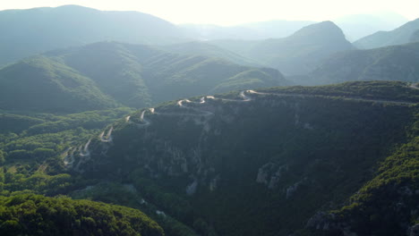 Aerial:-The-road-leading-to-Papingo-village-in-the-Zagori-region-of-Epirus,-Greece,-features-multiple-twists-and-turns