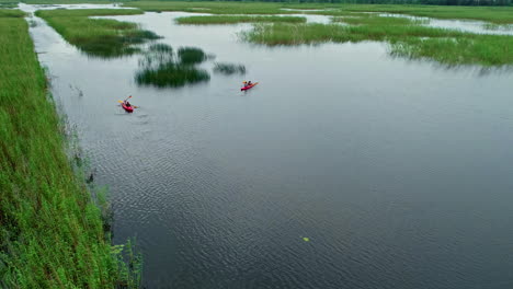 Aerial-Drone-zoom-out-rowboat-sailors-in-estuary-River-Water-landscape-Paddling