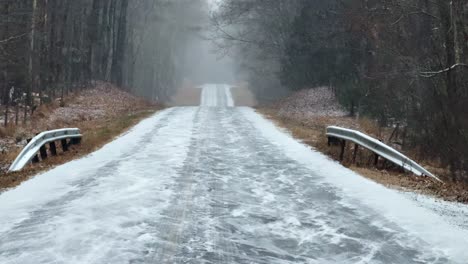 Heavy-snowfall-on-a-remote,-beautiful-forest-road-during-a-nor'easter