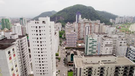 Aerial-shot-ascending-through-buildings,-revealing-the-entire-city-of-São-Vicente