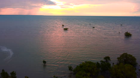 Aerial-drone-shot-looking-over-mangroves-to-wards-an-amazing-tropical-sunset-sunrise