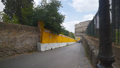 Rome-Immersive-POV:-Moving-In-Busy-Streets-to-Chiesa-Santi-Luca-e-Martina,-Italy,-Europe,-Walking,-Shaky,-4K-|-Crowd-In-Distance-Along-Path-In-Front-Of-Colosseum