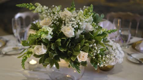 Wedding-decoration,-centerpiece-with-Gypsophila-paniculata-flowers,-white-roses-and-green-foliage