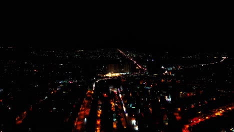 Paisaje-Urbano-Nocturno-Con-Calles-Iluminadas-Desde-Arriba