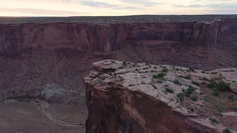 A-4K,-sunset-drone-shot-over-the-"Fruit-Bowl",-and-the-steep-cliffs-of-Mineral-Canyon,-a-famous-highlining-area-found-deep-in-the-heart-of-Moab’s-share-of-the-Colorado-Plateau,-in-Utah