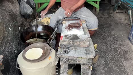 Shot-of-an-Indian-man-making-Rotis-on-traditional-Indian-stove-at-a-roadside-stall-in-Kolkata,-India