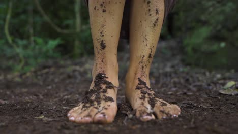 Close-up-slow-motion-shot-of-woman's-feet-covered-with-soil