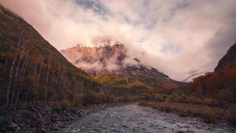 zoom-in-timelapse-Ordesa-national-park-valley-mountains-and-river-on-a-cloudy-and-misty-winter-afternoon-timelapse-of-clouds-rolling-over-mountain-peaks-in-fall-autumn-season