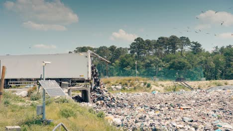 WIde-angle-view-of-a-semi-trailer,-creating-a-mountain-of-garbage