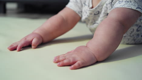tilting-shot-from-baby's-hands-to-his-face-while-he-attempts-to-learn-how-to-crawl