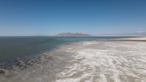 A-4K-drone-shot-over-the-perfectly-flat-Bonneville-Salt-Flats,-found-west-of-the-Great-Salt-Lake,-in-western-Utah,-with-a-shallow-layer-of-standing-water-flooding-the-vast-salt-plain’s-surface
