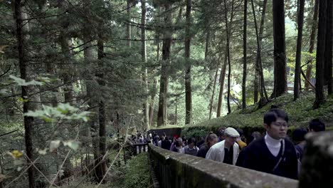 At-a-leisurely-pace,-tourists-ascend-the-staircase-leading-to-Okusha-Hoto-in-Nikko,-Japan,-to-explore-the-structure-that-houses-the-remains-of-Tokugawa-Ieyasu
