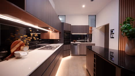 Luxurious-dark-wood-kitchen-with-gas-stove-strip-lighting,-and-walk-in-pantry