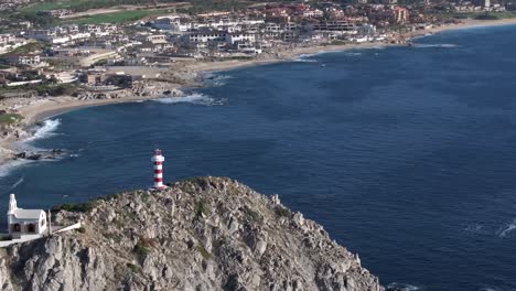 Establishing-aerial-of-El-Encanto-Lighthouse,-picturesque-landscape-view-over-Cabo-San-Lucas,-Mexico