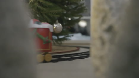 Nahaufnahme-Einer-Fahrenden-Beleuchteten-Festlichen-Spielzeugeisenbahn-Mit-Geschmücktem-Weihnachtsbaum-Und-Warmer-Beleuchtung