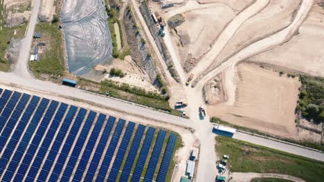 Wide-shot-below-solar-panels-and-a-landfill-site-for-non-recyclable-waste-in-France