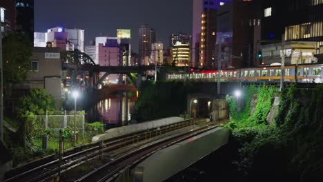 Trains-passing-in-the-night-in-Tokyo,-Ocha-no-Mizu-Station-background-View