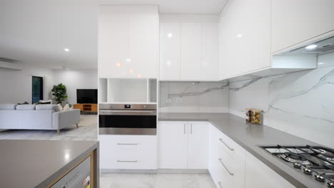 White-marble-tiled-wonder-kitchen-with-grey-stone-bench-tops-white-and-wooden-cupboard-doors