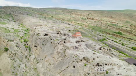 Basilica-church-in-Cave-city-of-Uplistsikhe-circled-by-drone-revealing,-Kura
