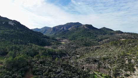 Drone-shot-showing-greened-mountains-of-Mallorca-near-Esporles-during-sunny-day---Panorama-shot