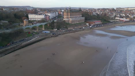 Wide-angle-drone-shot-The-Grand-Hotel-with-a-beautiful-cityscape-of-Scarborough-and-a-beach-in-front-of-it-during-daytime-in-North-Yorkshire,-England