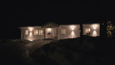 Cozy-Nordic-wooden-home-illuminated-at-night,-motion-view