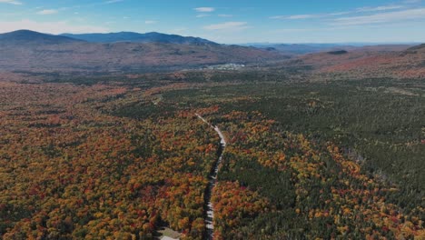 Panoramic-View-Over-Road-Between-Autumn-in-New-England-Forest-At-Daytime---Drone-Shot