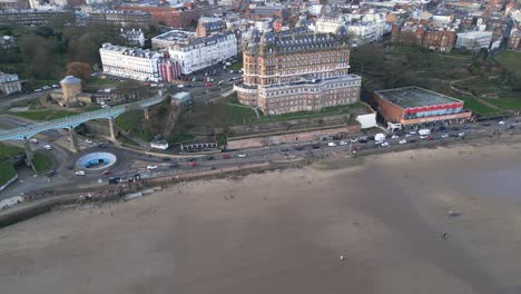 Aerial-forward-shot-of-the-vintage-Grand-Hotel-beside-a-coastline-at-Scarborough-bay-in-North-Yorkshire,-England