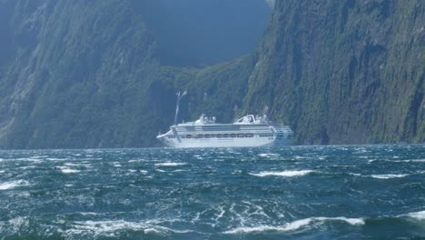 Spectacular-passage:-Massive-ferry-cruises-past-a-Milford-Sound-waterfall-in-captivating-stock-footage