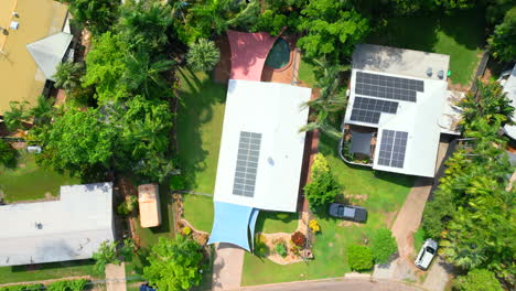 Rotating-aerial-drone-shot-of-suburban-residential-home-with-eco-friendly-ESG-solar-panel-on-the-roof