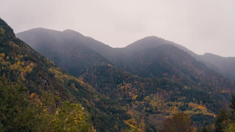 Close-up-detail-timelapse-Ordesa-national-park-valley-on-a-cloudy-rainy-and-misty-winter-morning-timelapse-of-clouds-rolling-over-mountain-peaks-in-fall-autumn-season