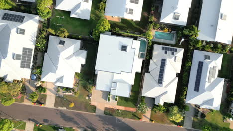 Aerial-drone-shot-of-upper-middle-class-street-with-all-white-roofs