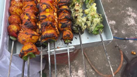 Closeup-shot-of-freshly-prepared-roasted-kebabs-of-potatoes,-broccolis,-paneer-kept-on-a-tray-at-a-stall-in-Kolkata,-India-during-daytime