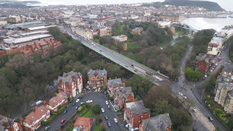 Cinematic-aerial-shot-of-a-bridge-connecting-two-cities-with-a-beautiful-cityscape-in-Scarborough-bay,-England