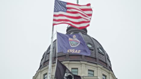 .Flags-waving-in-slow-motion-at-the-Kansas-state-capitol-building-in-Topeka,-Kansas-with-close-up-video