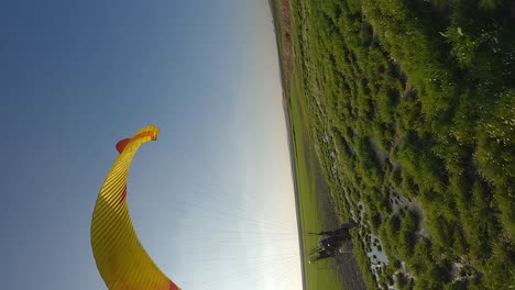 Vertical-format:-Paraglider-pilot-drags-foot-through-water-in-flyby