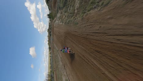 Vertical-format:-Motocross-rider-followed-by-FPV-drone-on-race-course