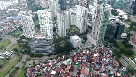 High-rise-buildings-in-Cebu-City,-towering-over-smaller-slum-community