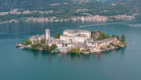 Impressive-Isola-di-San-Giulio-on-Lake-Orta,-Italy,-with-historic-buildings-surrounded-by-calm-waters,-aerial-view