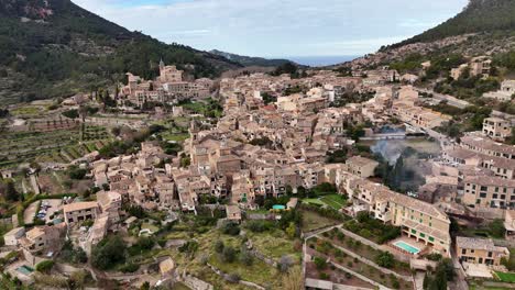 Aerial-view-of-old-village-of-Valldemossa-during-sunny-day-between-mountains-on-Mallorca-Island