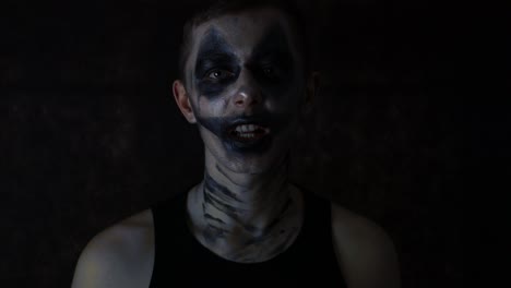 Close-up-of-a-young-man-with-dark-sad-Halloween-clown-makeup-talking-emotionally-to-the-camera
