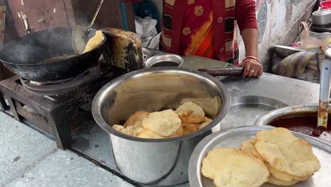 Closeup-shot-of-hardworking-woman-frying-Puri-at-a-roadside-stall-in-Kolkata,-India-during-winter-morning
